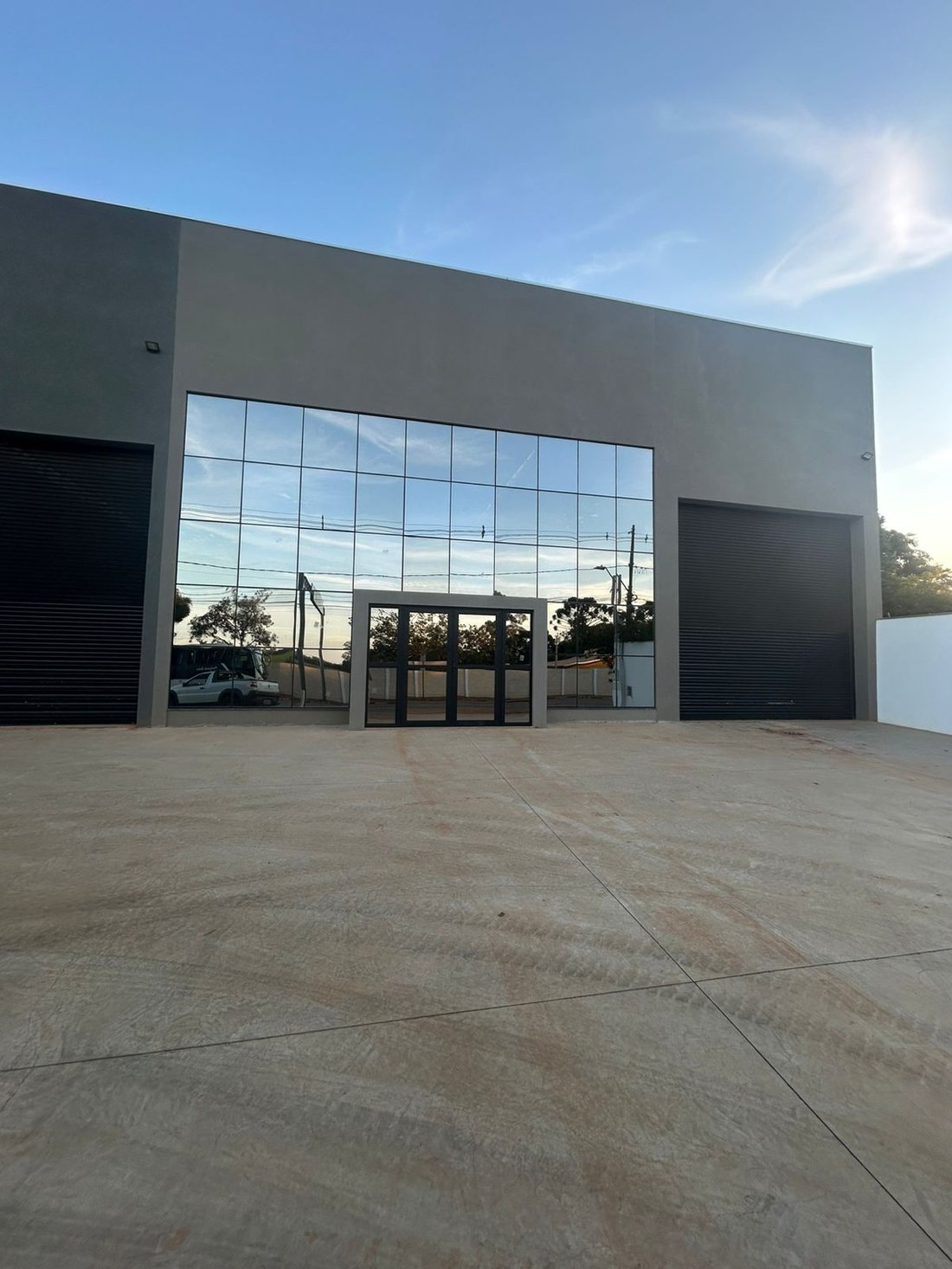 Fachada de um galpão com entrada em vidro espelhado