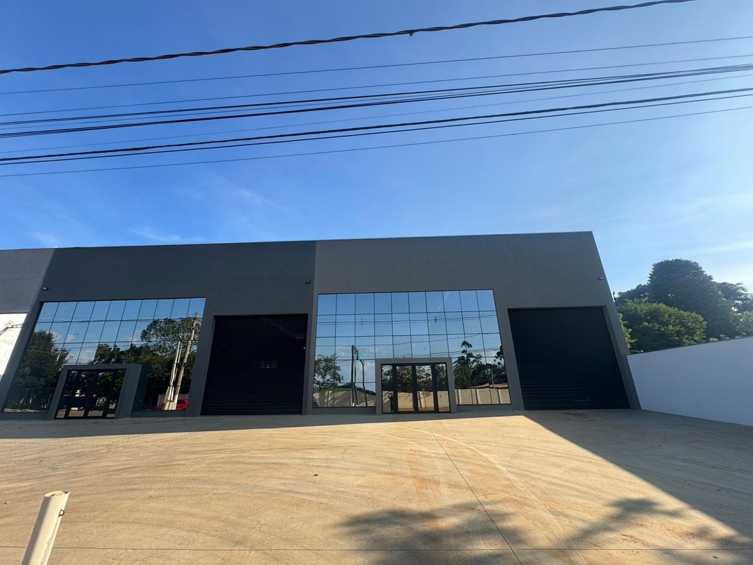 Fachada do conjunto de galpões, com esquadrias pretas e vidro espelhado